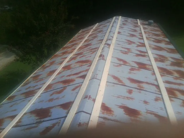 Rusted metal roof panels with new wood purlins before replacement — Storm Damage Roof Repair in Harpswell by Roofing Brothers