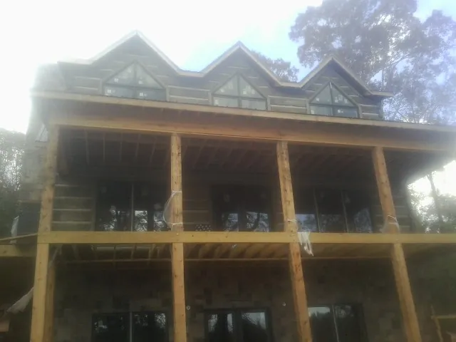 Dormers and porch framing on a large log home under construction in Harpswell