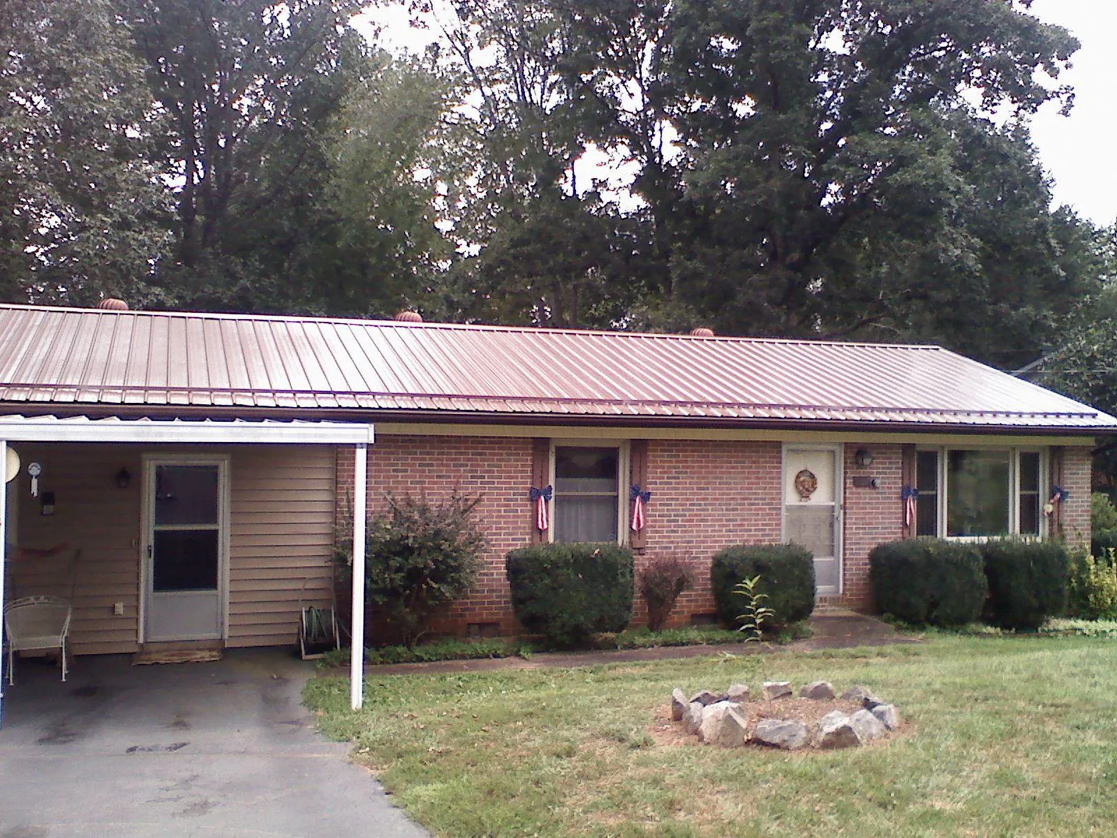 Bronze metal roof and carport on a brick ranch home — Roof Repair work by our crew in Harpswell